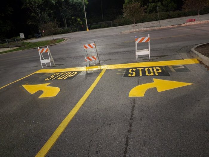 Yellow stop legends, turn arrows and lane lines striped on asphalt