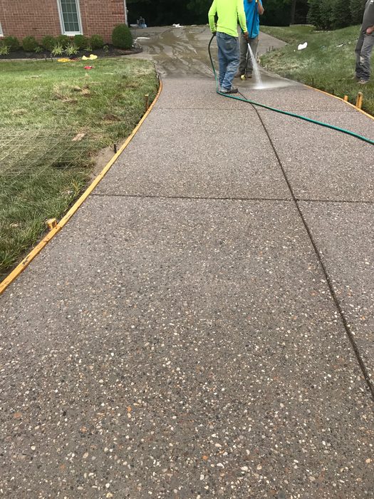 Crew washing a new exposed aggregate concrete driveway