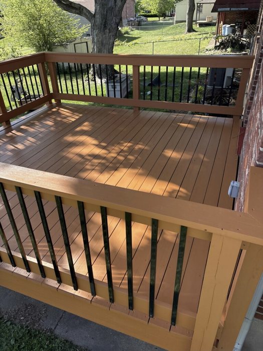Wood deck in a cedar-tone stain with black metal balusters
