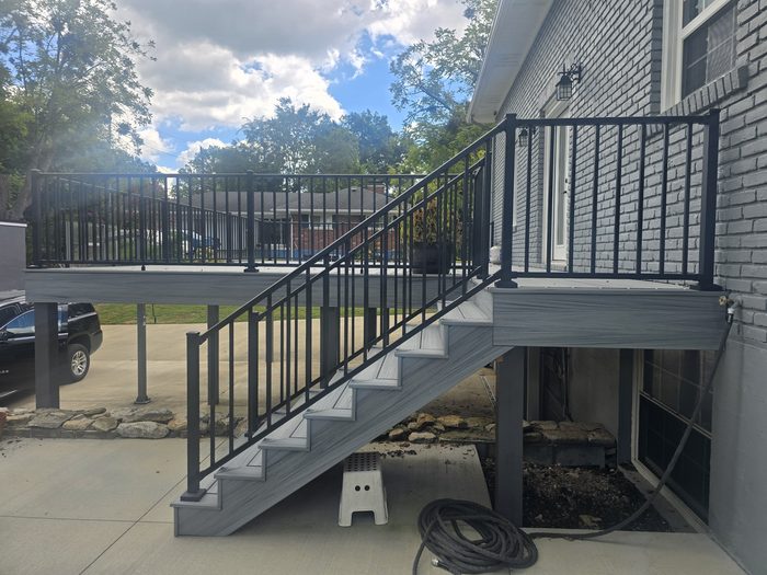 Raised composite deck with stairs and black aluminum railings