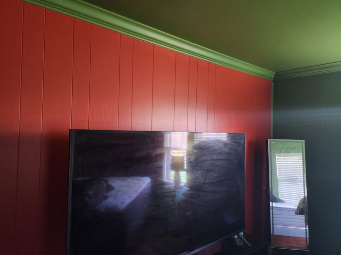 Bedroom with painted paneling, green crown molding and ceiling
