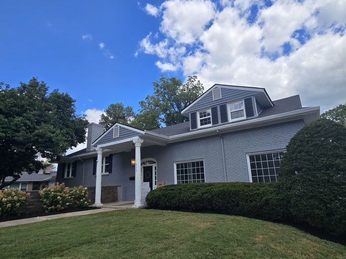 Home exterior with gray painted brick and siding and white trim